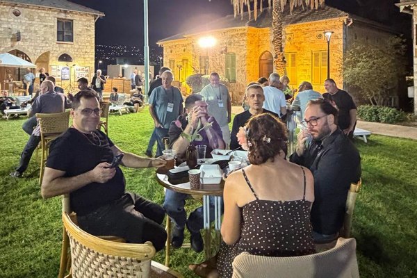 באי.ות הכנס במפגש סביב שולחנות על הדשא